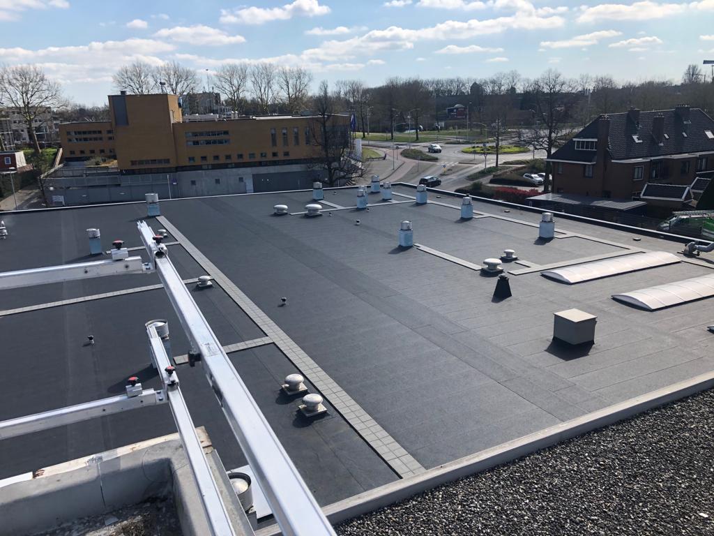 Plat dak met bitumen dakbedekking, ventilatiekappen en lichtstraten